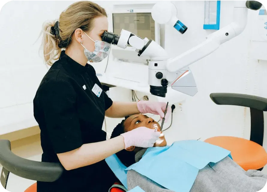 Dentist examining a patient with a dental microscope
